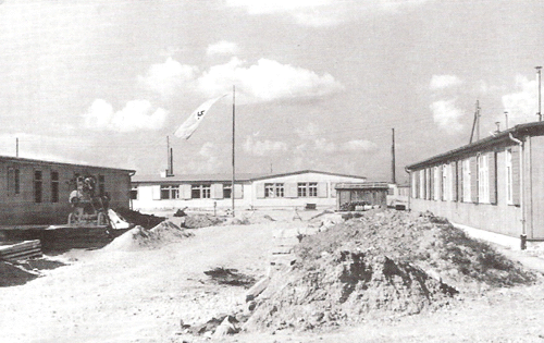 Straße zwischen Bauleitungsbaracke (rechts) und Operationsbaracke (links) im Juni 1940.