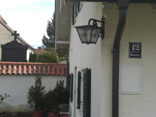 Das »Mesnerhäusl« in der Muspillistraße 12, ersetzt über seine ganze Länge die Friedhofsmauer von St. Lorenz, (Foto: dietlind pedarnig, 2008.), was auch die obere Luftbildaufnahme wunderbar verdeutlicht.