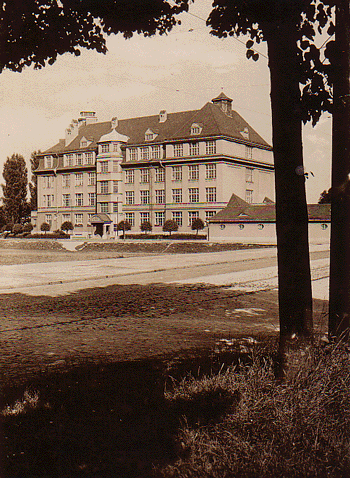 Historische Ansichtskarte (© privat): die Gebeleschule ca. 1920/30er-Jahre; im Vordergrund die heutige Denninger Straße – schmal und mit Kopfsteinpflaster.