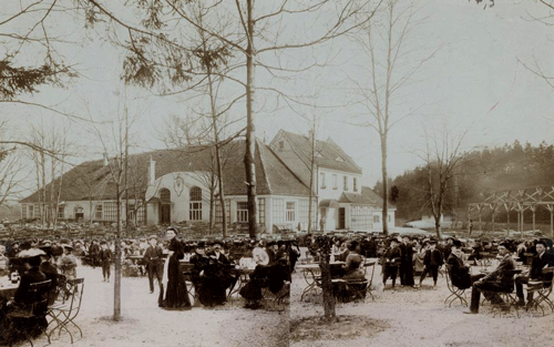 Blick über den Wirtsgarten zum Gaststättengebäude der »Restauration Herzogpark«, heute Flemingstraße 16, im Jahr 1905 mit Gästen (Fotomontage). Fotografie Sammlung Valentin. Quelle: Stadtarchiv München, Sign. DE-1992-FS-NL-KV-0803. URL: http://stadtarchiv.muenchen.de/scopeQuery/detail.aspx?ID=409708