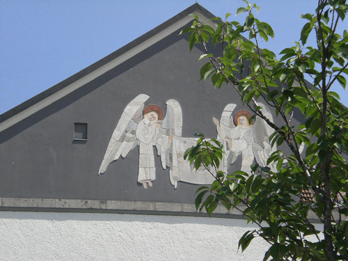 Mosaik »Engel mit dem Schweißtuch Veronikas« von Prof. Günther Grassmann unter dem Dachgiebel auf der Westseite. Rechts hinter den Zweigen verborgen das Wappen von Kardinal Faulhaber. © dietlind pedarnig, 2007