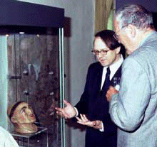 Museumsleiter Dr. Hermann Reidel mit Regierungspräsident Weidinger vor dem Haupt des Hl. Emmeram, Gipsabguss nach dem Entwurf von Dr. Dr. Röhrer-Ertl, Anthropologische Staatssammlung München, aus der Werkstatt Rappenegger, 1988. Quelle: www.bistumsmuseen-regensburg.de