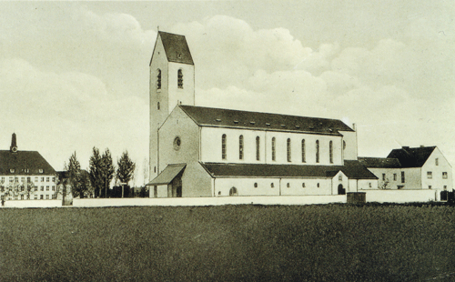Pfarrkirche St. Emmeram von der Ostpreußenstraße aus gesehen (privates Foto), Datierung unbekannt; links die Ostpreußenschule, auf der Wiese im Vorderrund stehen heute Wohnhäuser und die Bezirkssportanlage Englschalking.