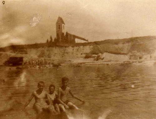 Ungefähr zwischen Memeler und Dorpater Straße war früher eine riesige Kiesgrube. Im Sommer hatten die Kinder hier ihren Badespass im Winter sind sie mit Karacho die steilen Kiesufer mit den Schlitten hinunter gebrettert.Im Hintergrund die Kirche St. Emmeram. (Foto privat)