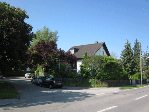 Die Straße ist nur mit Kies aufgeschüttet und aus dem gleichen Blickwinkel 2013. Das zweite Haus von links auf der historischen Aufnahme steht heute noch in dieser Form, lediglich ein Anbau ist dazugekommen