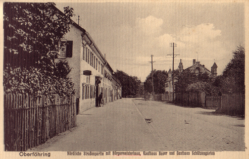 Das »Bürgermeisterhaus« mit den markanten Türmchen (rechter Bildrand) auf einer Postkarte aus dem Jahr 1913. Bildquelle: Ansichtskartensammlung: "Die Gemeinde Oberföhring bei München in Wort und BiId vor der Verleibung in die Großstadt", Verlag Hans Pernat. Gegenüber ist das Kaufhaus Bauer und das Gasthaus »Schützengarten« zu sehen.