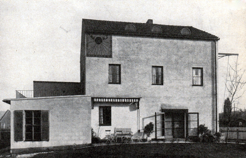 Gartenseite Haus Gellertstraße 10 mit Sitzplatz Südseite; Sonnenuhr aus Zementsgraffito von Prof. Lois Gruber. Rechter Hand der Schaukelbalken, wie alle Eisenteile rot gestrichen. Aus: Die Bauzeitung, Stuttgart 5. April 1932, S. 113.