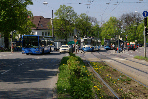 Der Herkomerplatz 2009: ein reiner Verkehrsknotenpunkt; hpt©Verein für Stadtteilkultur im Münchner Nordosten e.V. Im Hintergrund das Gebäude quer ist das Schreibwarengeschäft/Lebensmittelmarkt am Herkomerplatz 2.