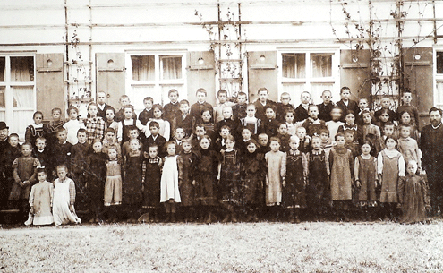 Schulklasse der alten Schule in Oberföhring, 1910. Ganz links: HH geistlicher Rat, Distriktsschulinspektor Georg Manseicher, ganz rechts: Hauptlehrer Michael Schletzbaum. Quelle: s.o.