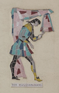 Mosaiken von Figuren aus Opern von Richard Strauss an den Fassaden der Reihenhäuser in der Richard-Strauss-Straße im Abschnitt zwischen Denninger Straße und Effnerplatz. Im Rahmen der Untertunnelung entstehen hier neue Wohneinheiten als Lärmschutzmaßnahmen, daher wurde den bestehenden Reihenhäusern 2007 die Adresse "Amberger Straße" neu zugewiesen. Die Mosaiken können der Künstlerin Mecke-Steger zugeordnet werden – sie blieben bei den Baumaßnahmen erhalten. Datierung unbekannt. hpt © Verein für Stadtteilkultur im Münchner Nordosten e.V. (2008)