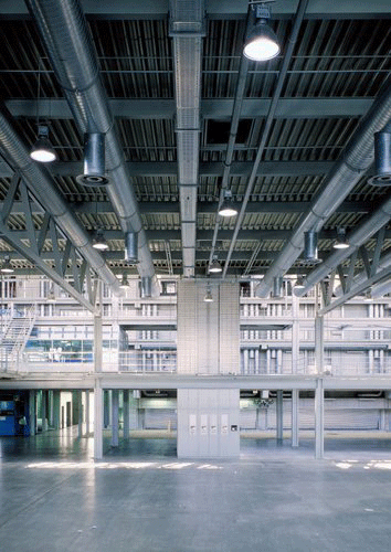 Blick in den Neubau 1985 kurz vor der Inbetriebnahme, links ist die erste Rotationsmaschine bereits montiert. Tageslicht und ein dezent in Grau und Silber gehaltenes Farbkonzept unterstützen die großzügige Wirkung von ablesbarer Konstruktion und geometrisch penibel angeordneter Sichtinstallation. ( mit freundlicher Genehmigung © Ingrid Voth-Amslinger)
