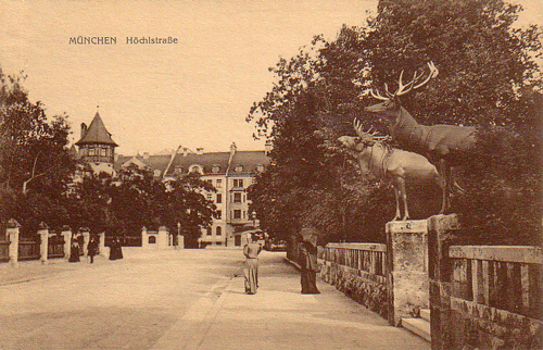 Blick in die Höchlstraße, rechts die beiden Bronzeskulpturen von Düll und Pezold auf den Eingangspylonen der Villa »Lindenhof«, im Hintergrund die Häuserfronten an der Einmündung Höchlstraße / Ismaninger Straße; Ansichtskarte, 1910 © privat.