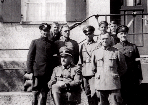 Polizeibeamte in Denning mit Revierführer Müller (sitzend), stellvertretendem Revierführer Ohneberg (Mitte stehend mit Mütze) in der Uniform der Reichspolizei; außen zwei Angehörige der Hilfspolizei, 1939. © Verein für Stadtteilkultur im Münchner Nordosten e.V.